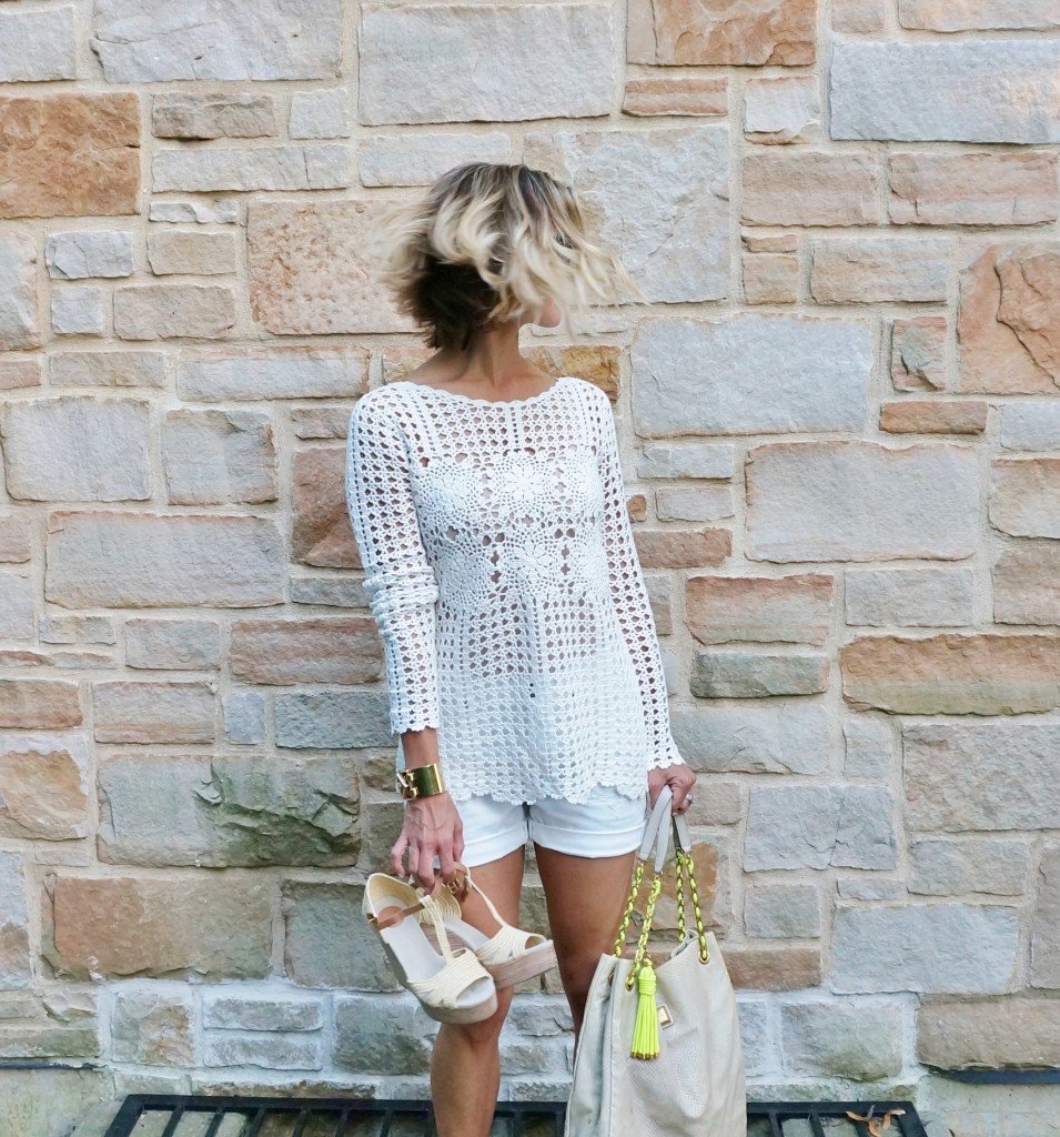 Neutral sweater, white shorts, tote, wedges, and sunglasses
