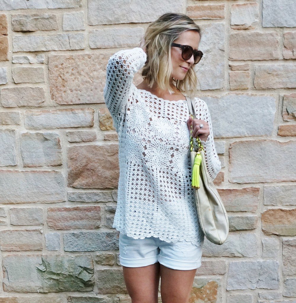 Neutral sweater, white shorts, tote, wedges, and sunglasses