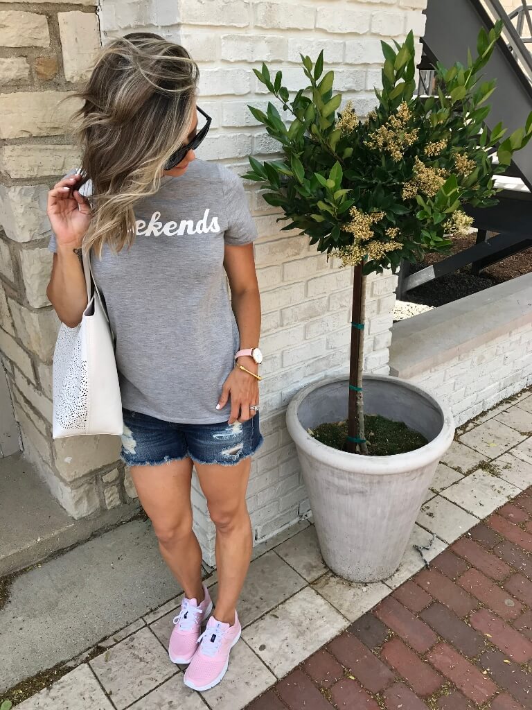 Graphic tee, cut off shorts, tote, sunglasses, and sneakers