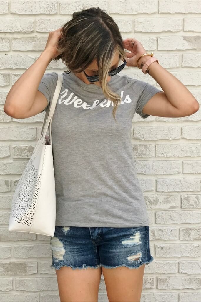 Graphic tee, cut off shorts, tote, sunglasses, and sneakers
