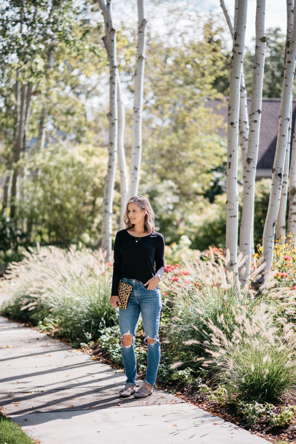 Black long sleeve tee, mom jeans, mules, and clutch