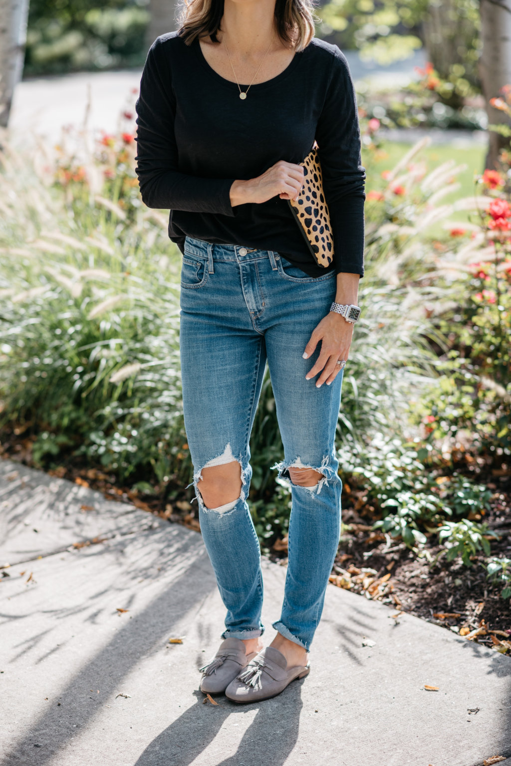 Black long sleeve tee, mom jeans, mules, and clutch