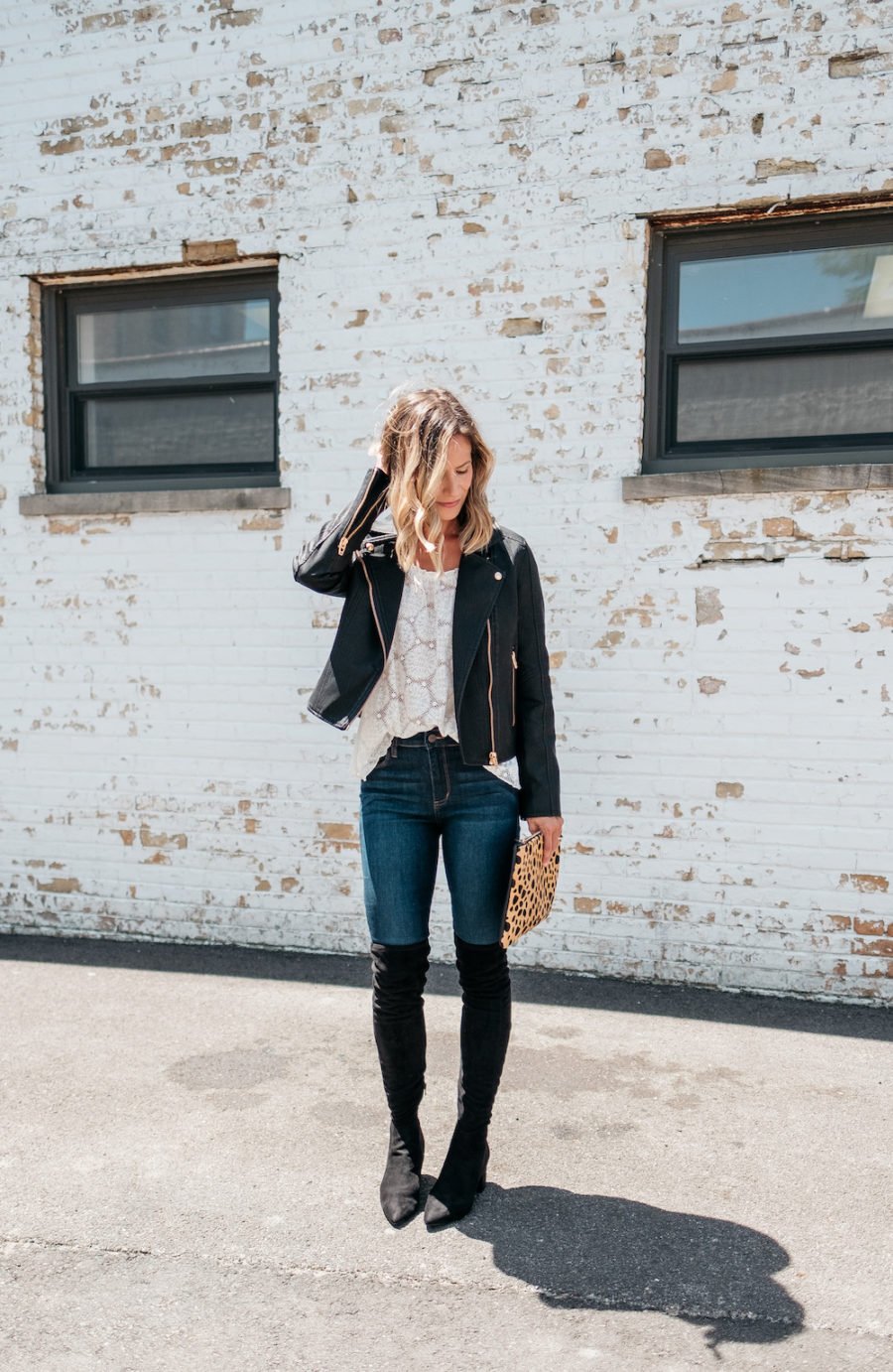 White blouse, denim jeans, moto jacket, over the knee boots 