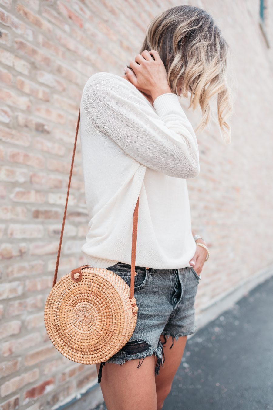 White long sleeve tee, black cut offs, sandals, straw bag, and sunnies