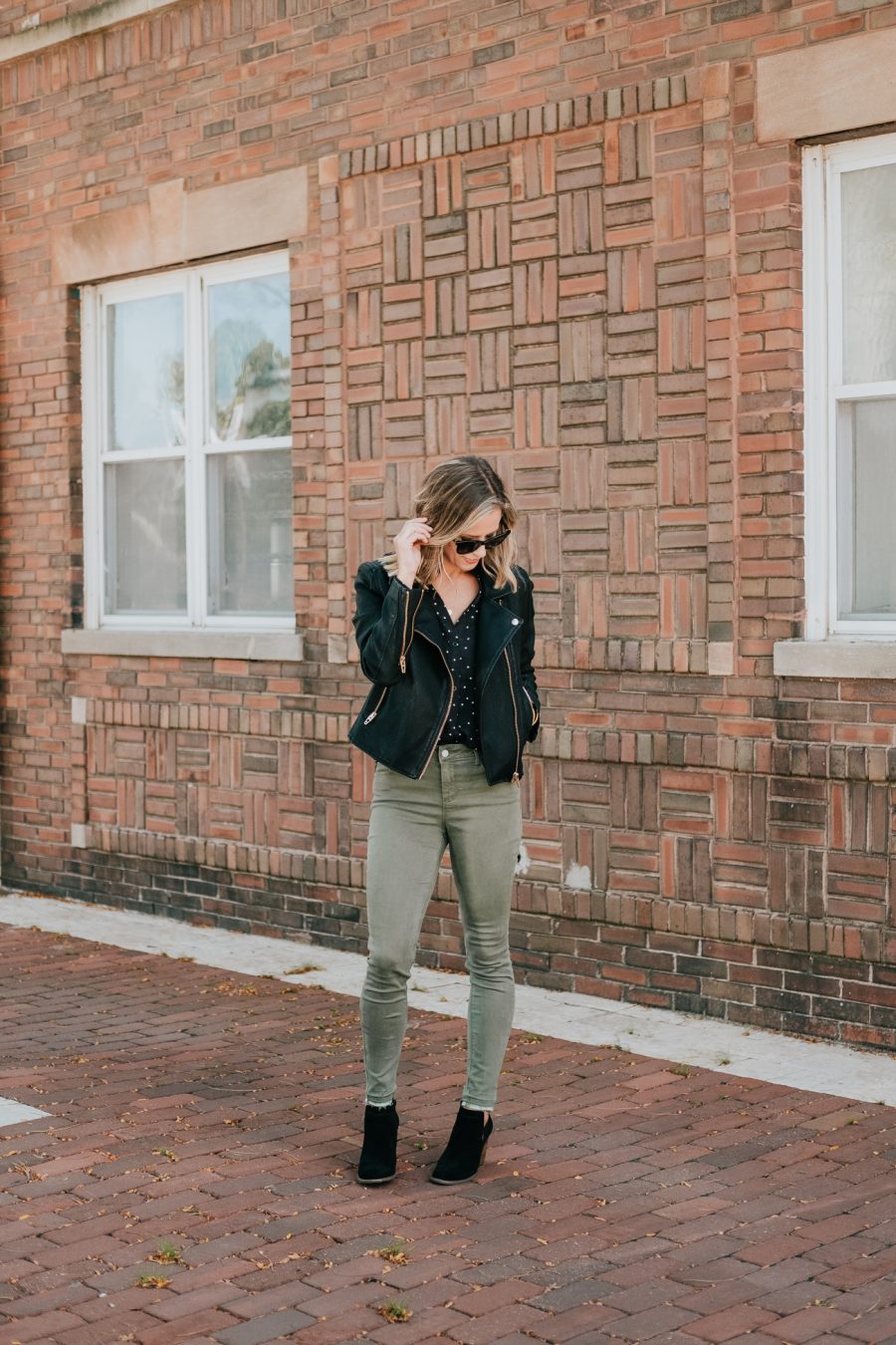 Thanksgiving outfit ideas: Suzanne wearing a moto jacket and olive skinny jeans