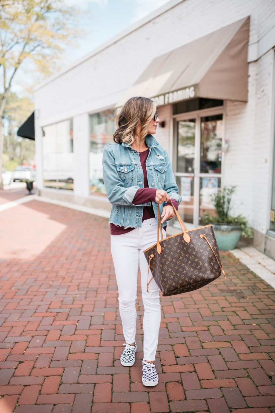 White denim, long sleeve tee, denim jacket, Vans sneakers, and Louis Vuitton bag