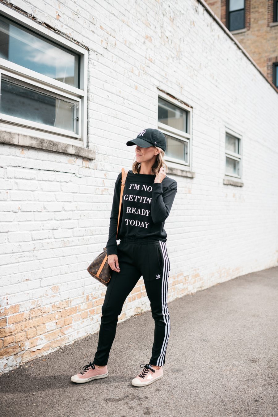 Suzanne wearing a graphic t-shirt and Adidas joggers 