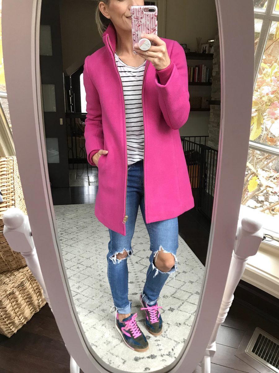 Pink coat, striped tee, jeans, and sneakers