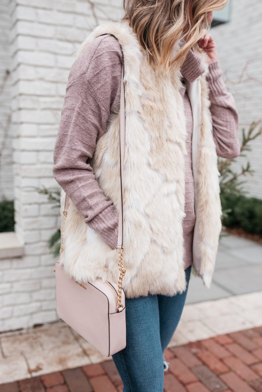 pink turtleneck, faux fur vest, skinny jeans, crossbody, and booties