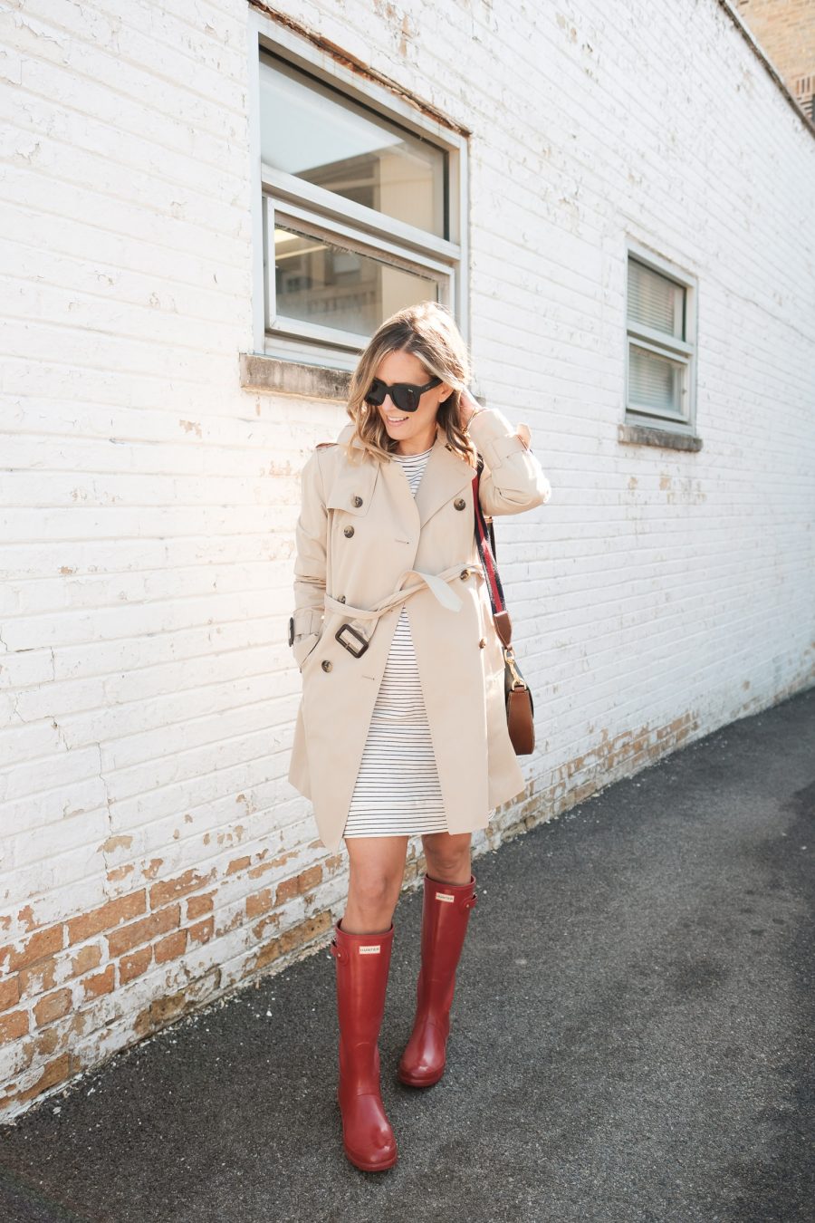 $30 sweatshirt dress with a trench coat, rain boots, and crossbody bag