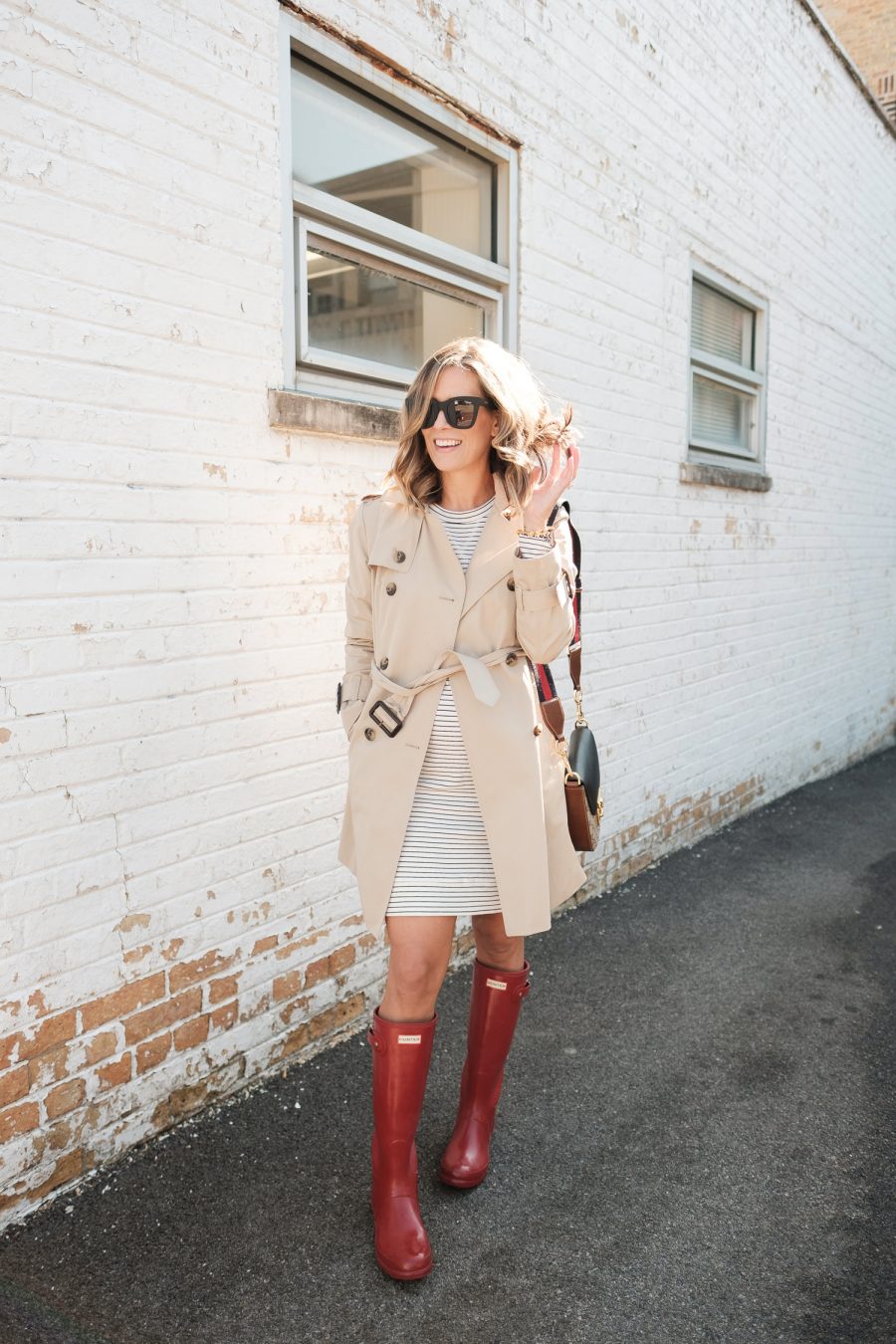 $30 sweatshirt dress with a trench coat, rain boots, and crossbody bag