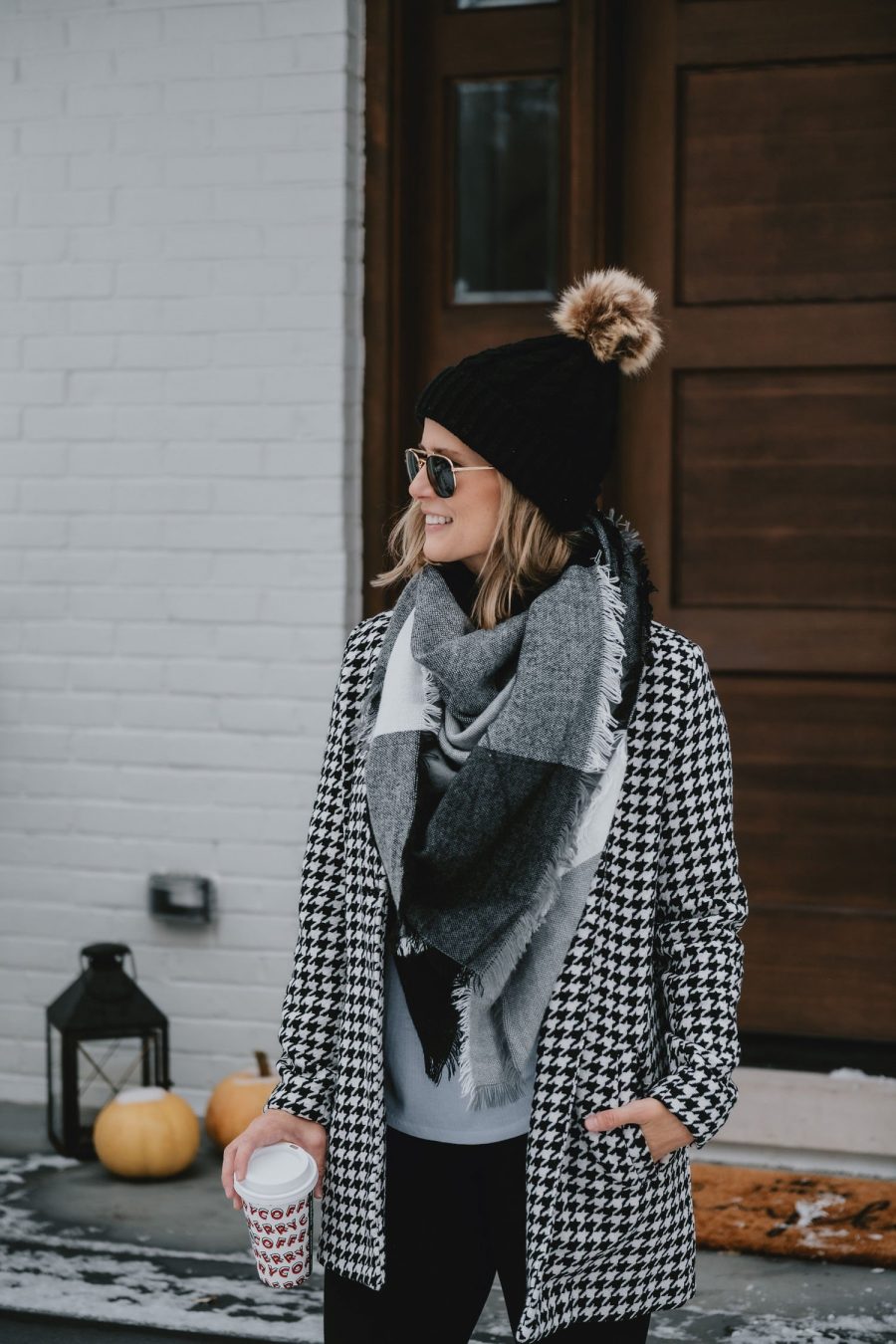 Thanksgiving outfit ideas: Suzanne wearing a houndstooth jacket, plaid scarf, and black beanie