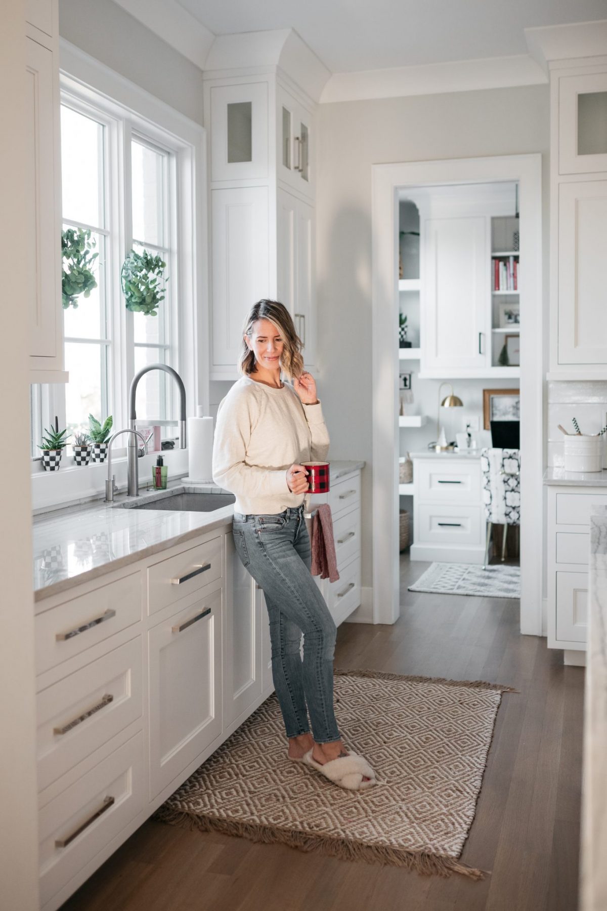 Suzanne standing in her kitchen, featuring the jute rug in front of the sink