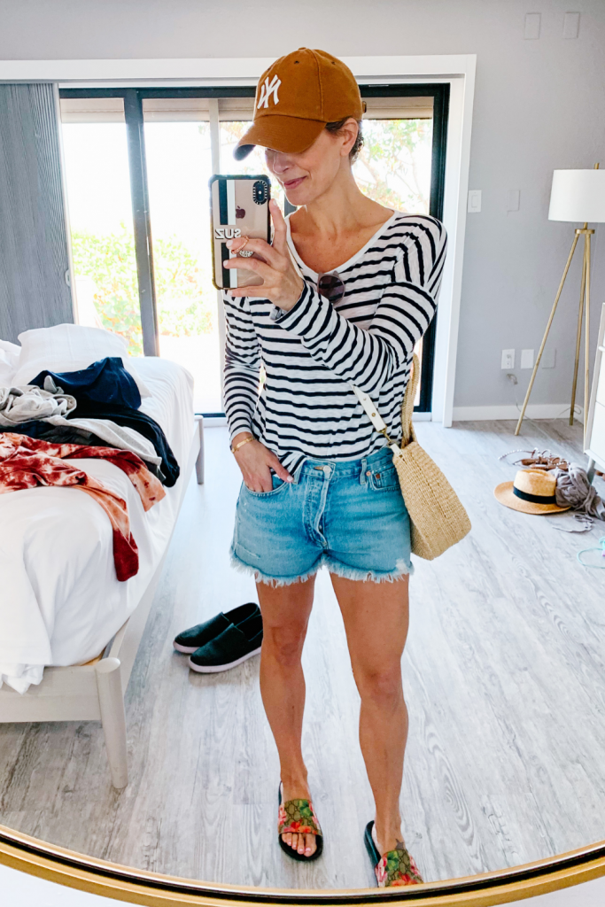 What to pack for spring break, casual outfit: striped tee, denim shorts, straw bag, ball cap