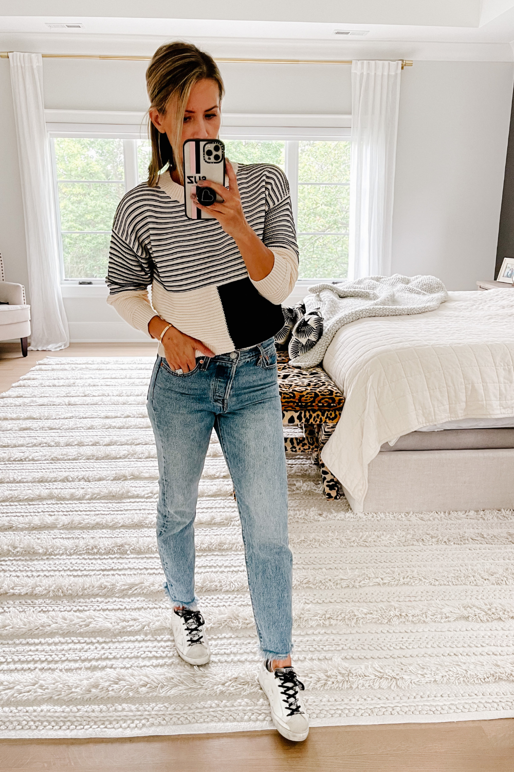 Suzanne wearing an Amazon colorblock sweater, denim jeans, and Golden Goose shoes