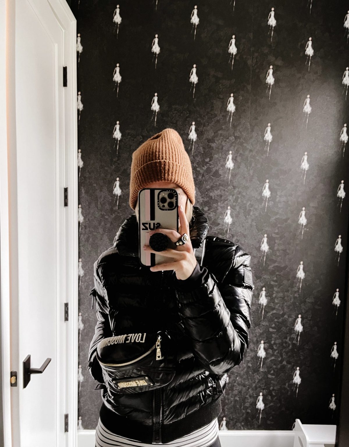 Suzanne wearing a puffer, beanie, and belt bag