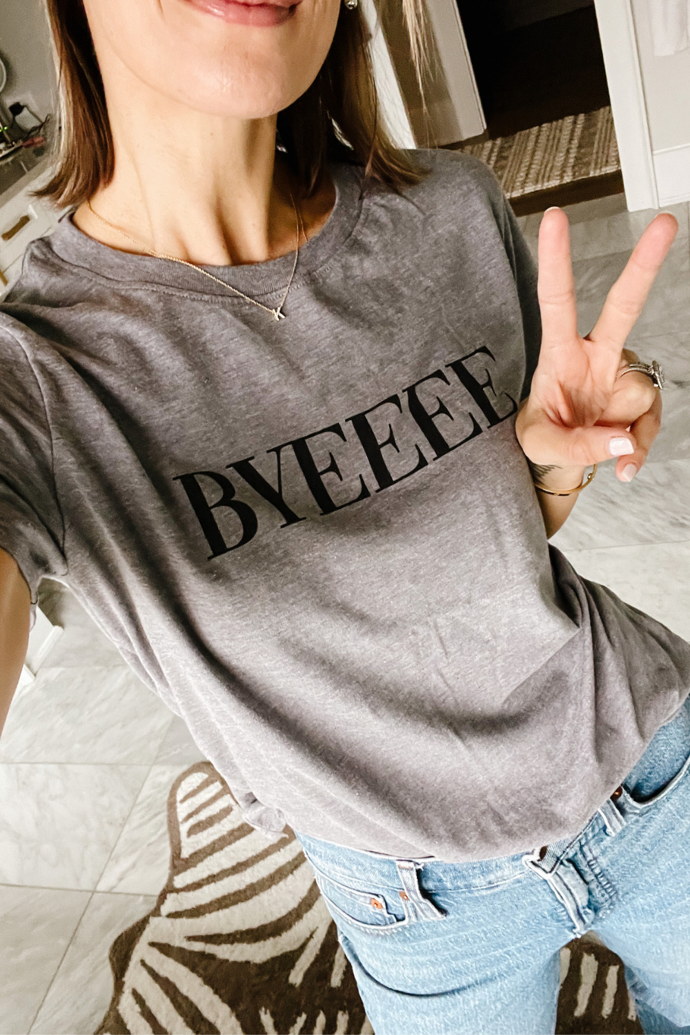 Suzanne wearing a "Byeeee" graphic tee and denim