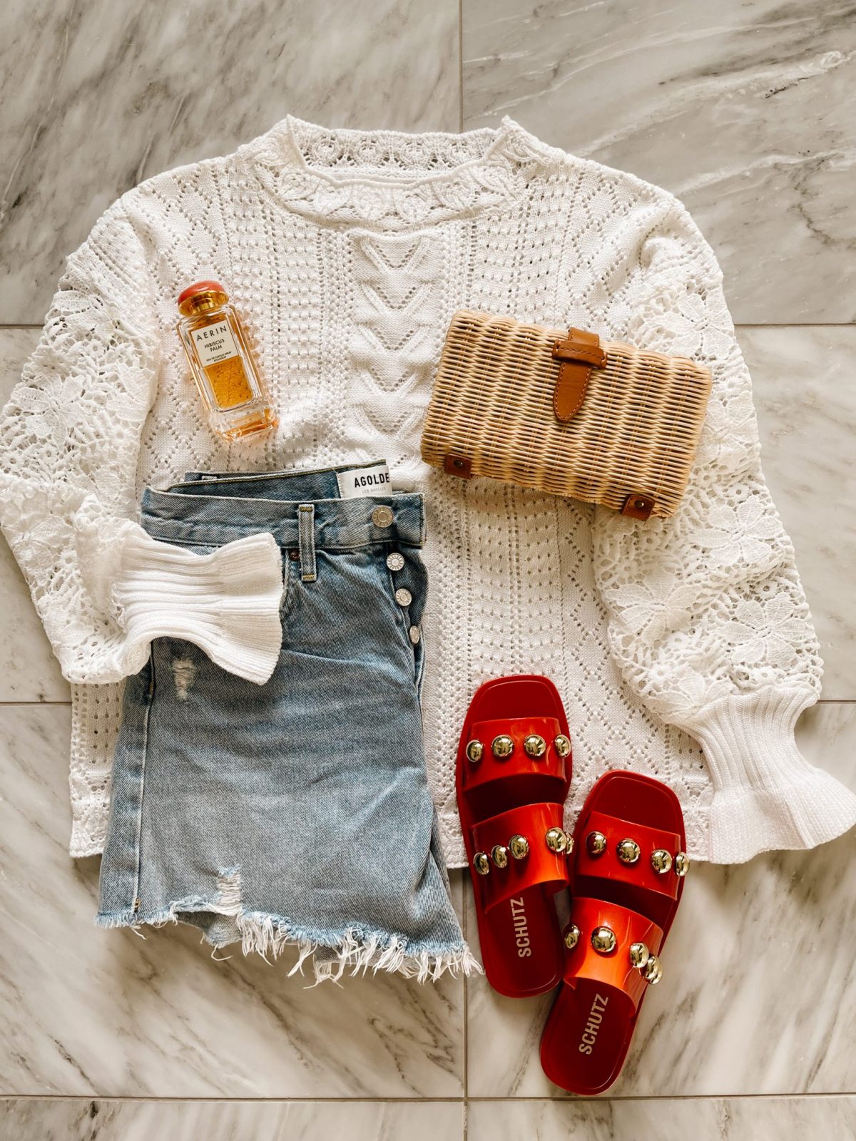 Sweater, denim shorts, straw purse, and sandals