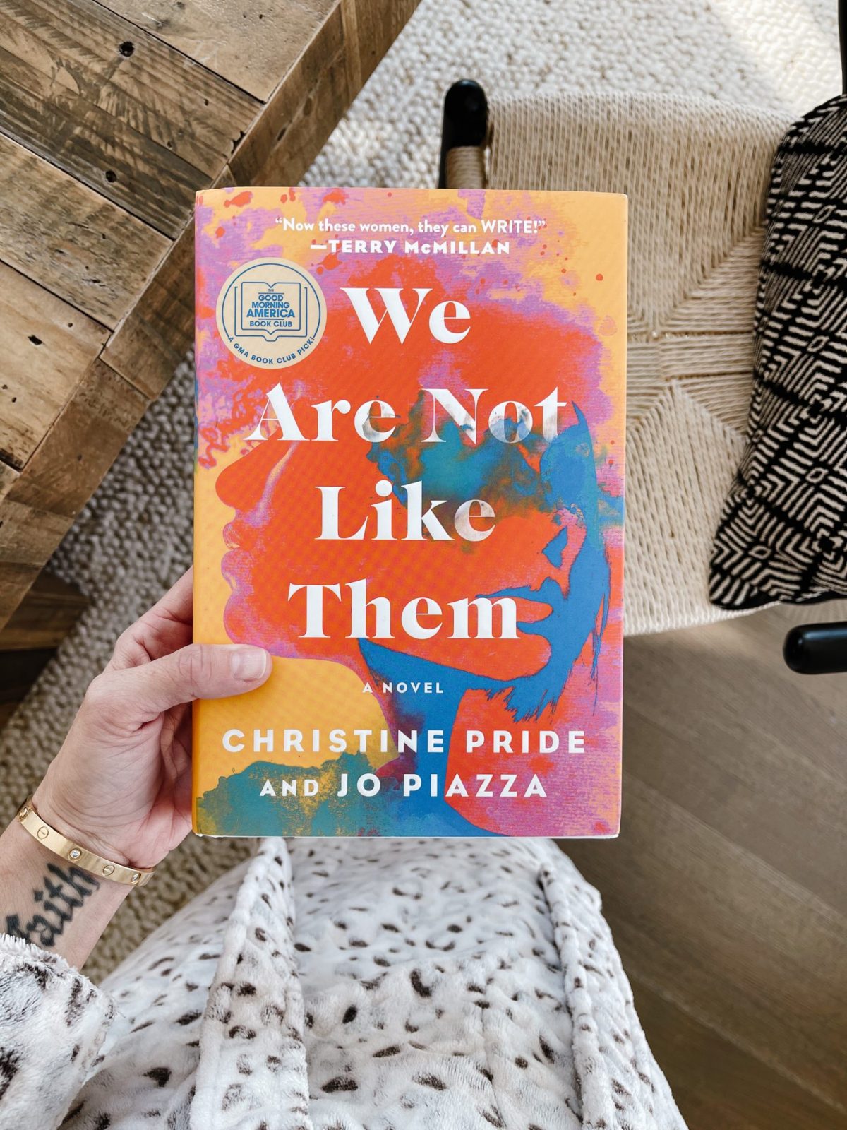 Suzanne holding the book, We Are Not Like Them by Christine Pride and Joe Piazza