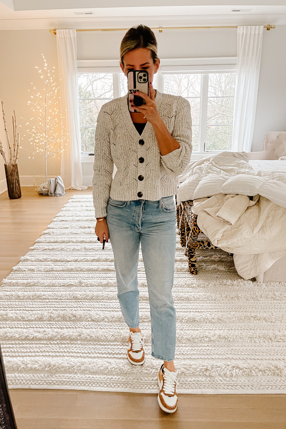 Suzanne wearing a cardigan, jeans, and sneakers