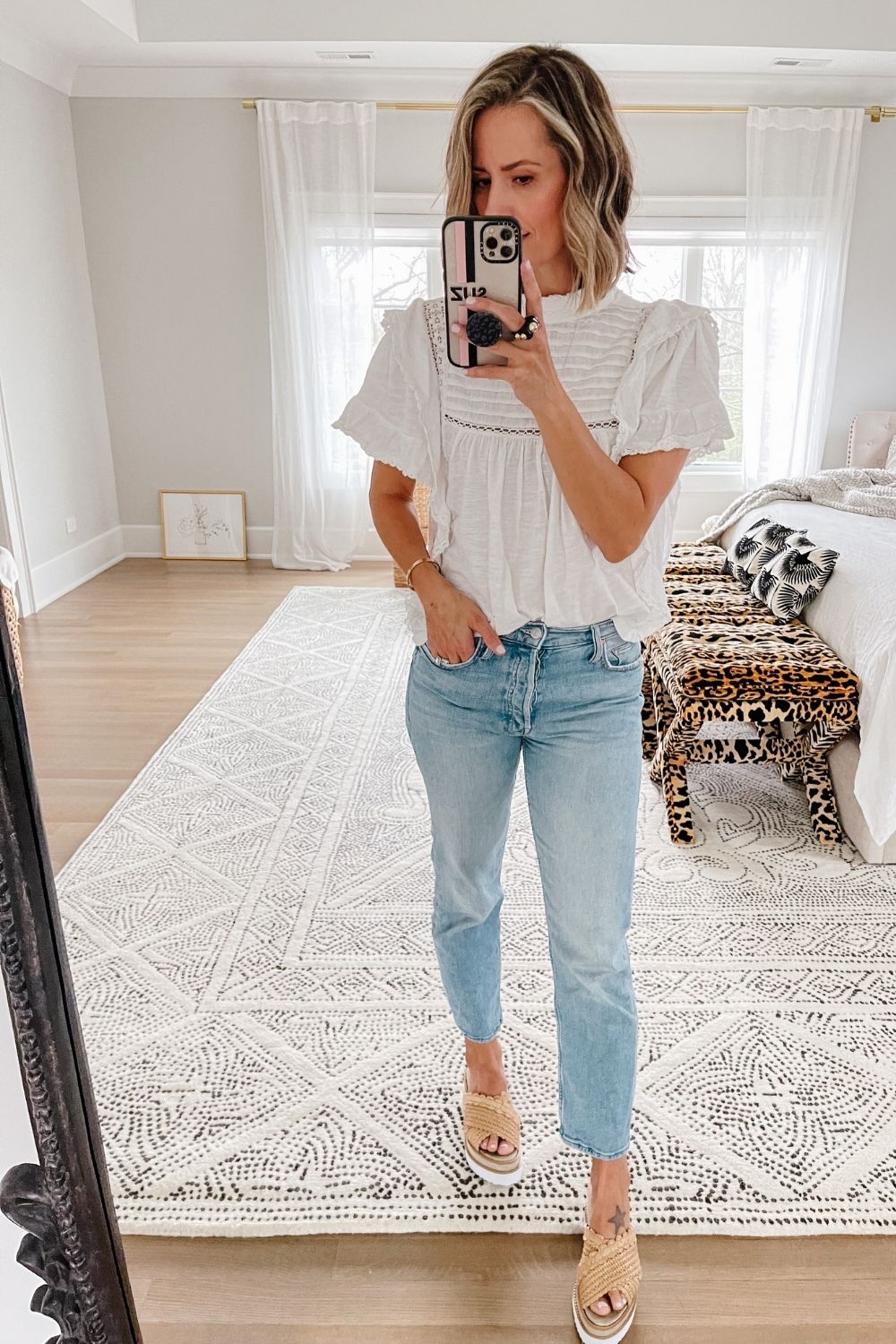 Suzanne wearing a white Free People blouse, denim jeans, and wedges