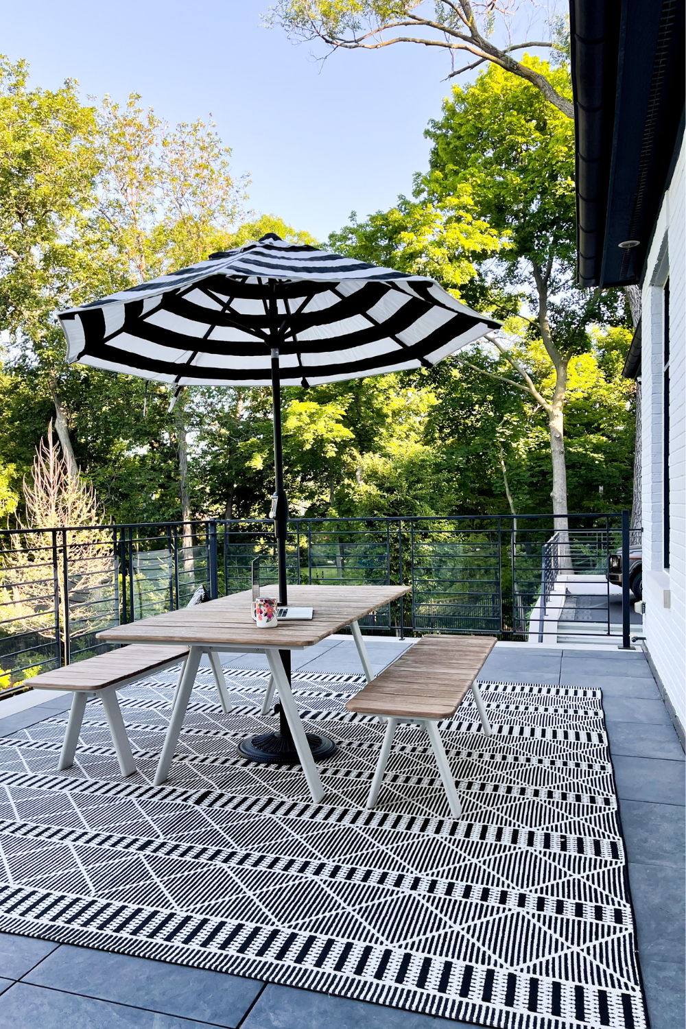 Balcony styling: picnic table, black and white rug, umbrella