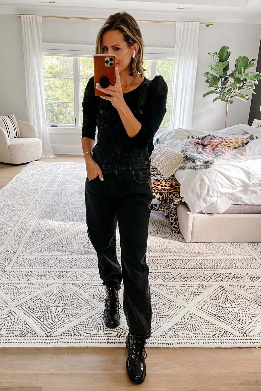 Suzanne wearing black overalls and a puff sleeve top