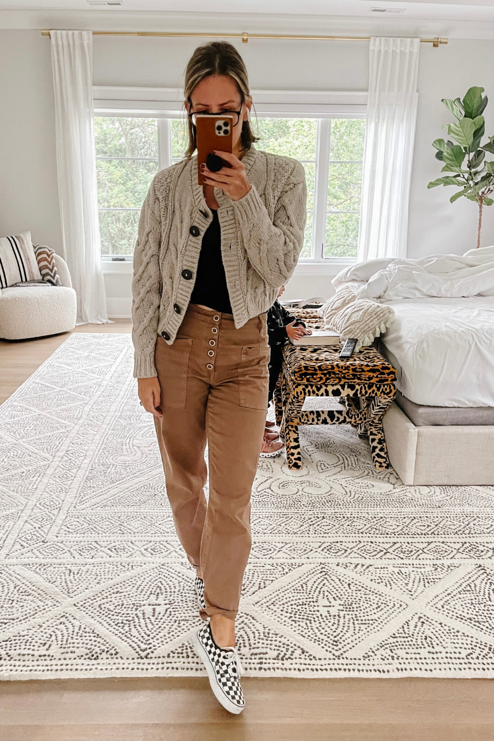 Suzanne wearing Pistola trousers, a cardigan, and checkered Vans