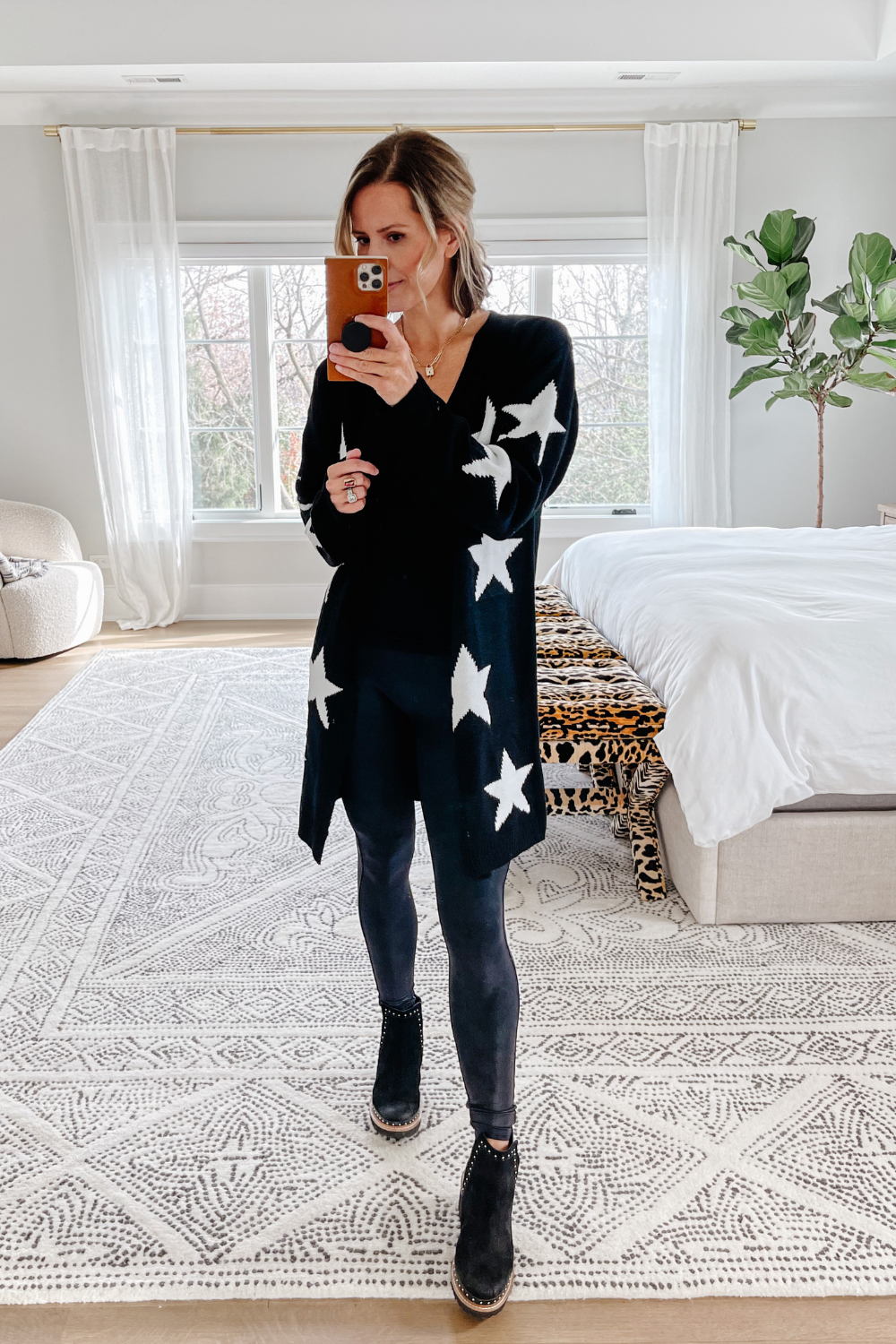 Suzanne wearing a star cardigan. Spanx leggings, and booties 