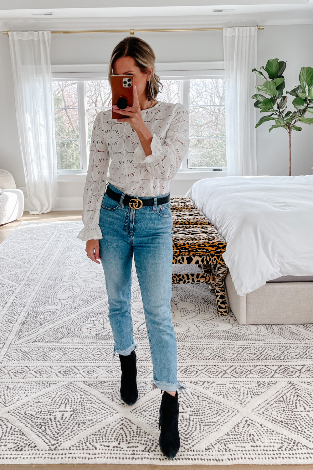 Suzanne wearing an embroidered floral blouse and denim jeans