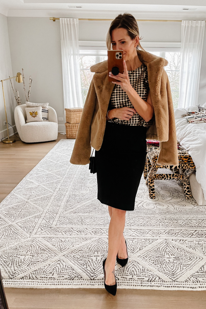 Suzanne wearing a black pencil skirt and faux fur jacket for the holidays