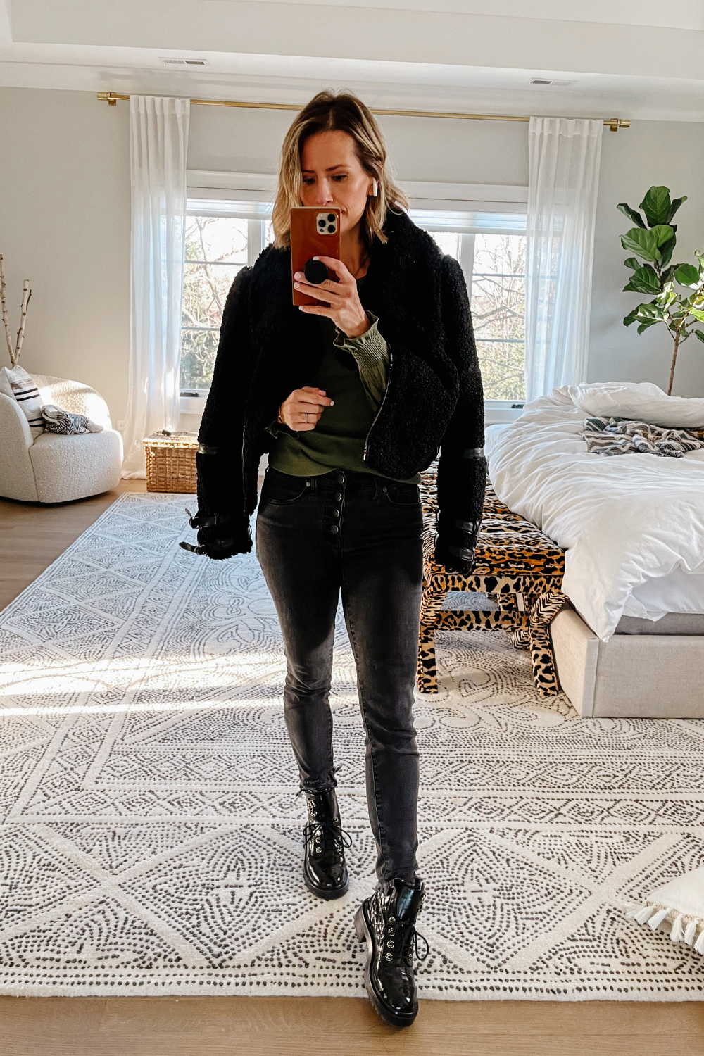 Suzanne wearing a faux fur jacket, black jeans, combat boots