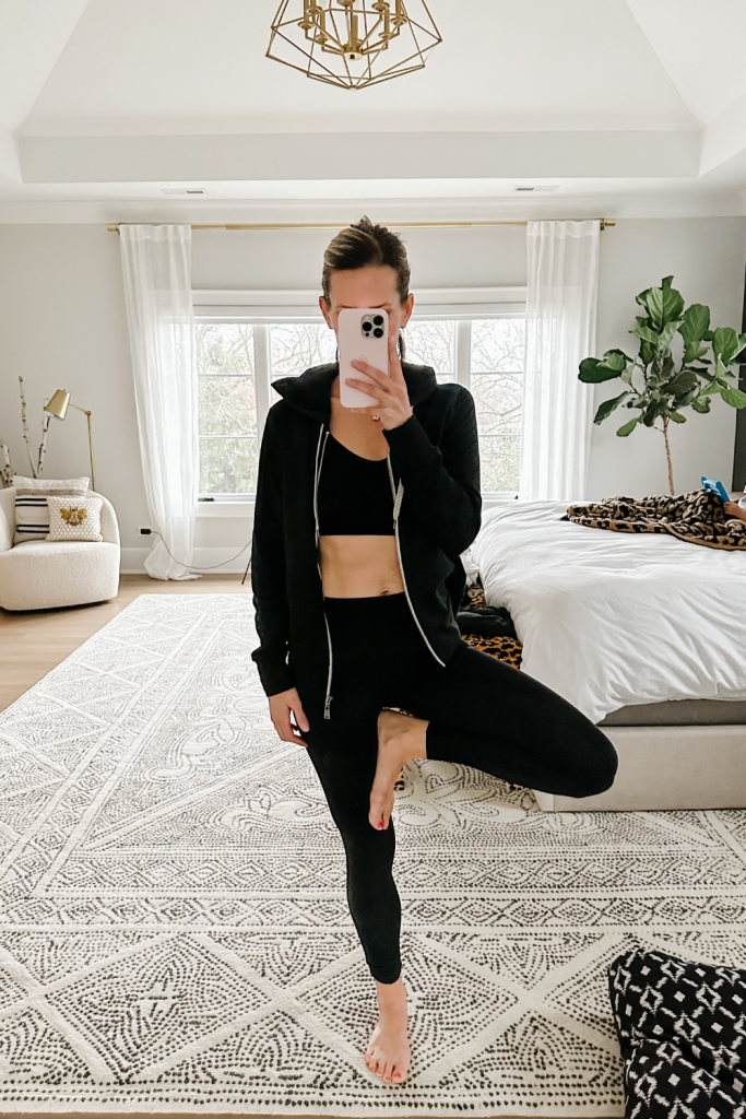 Suzanne wearing activewear: leggings, a sports bra and a zip up hoodie 
