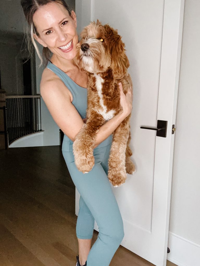 Suzanne holding her dog wearing an Amazon activewear set