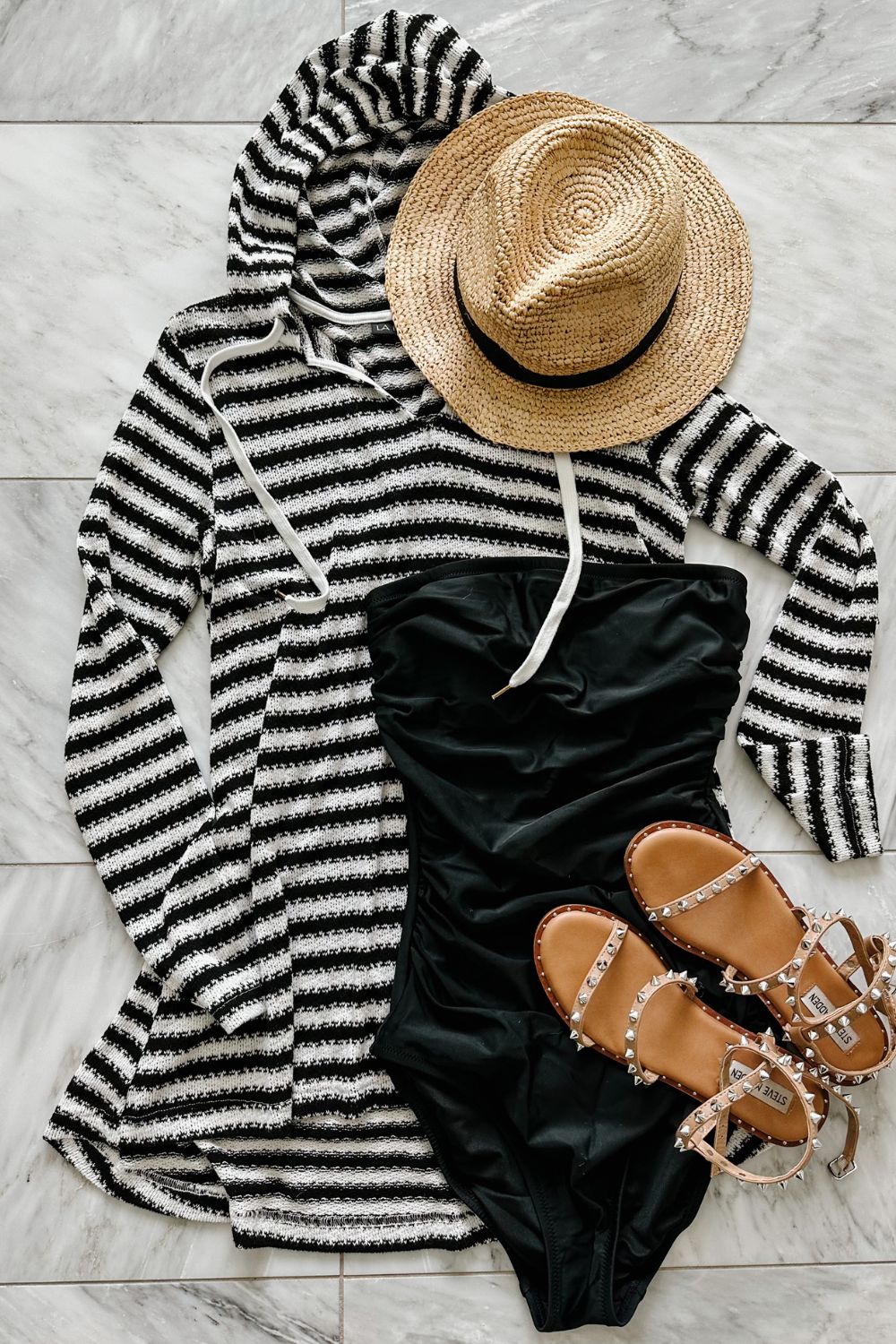 A one piece swimsuit styled with a cover up, sandals, and a straw hat