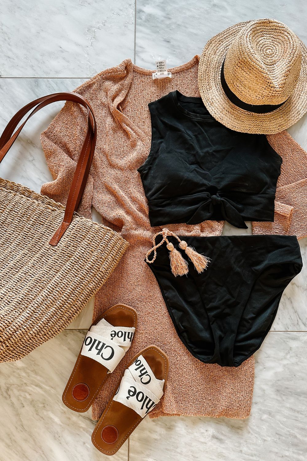 A high waisted bikini styled with a cover up, sandals, straw bag and a hat
