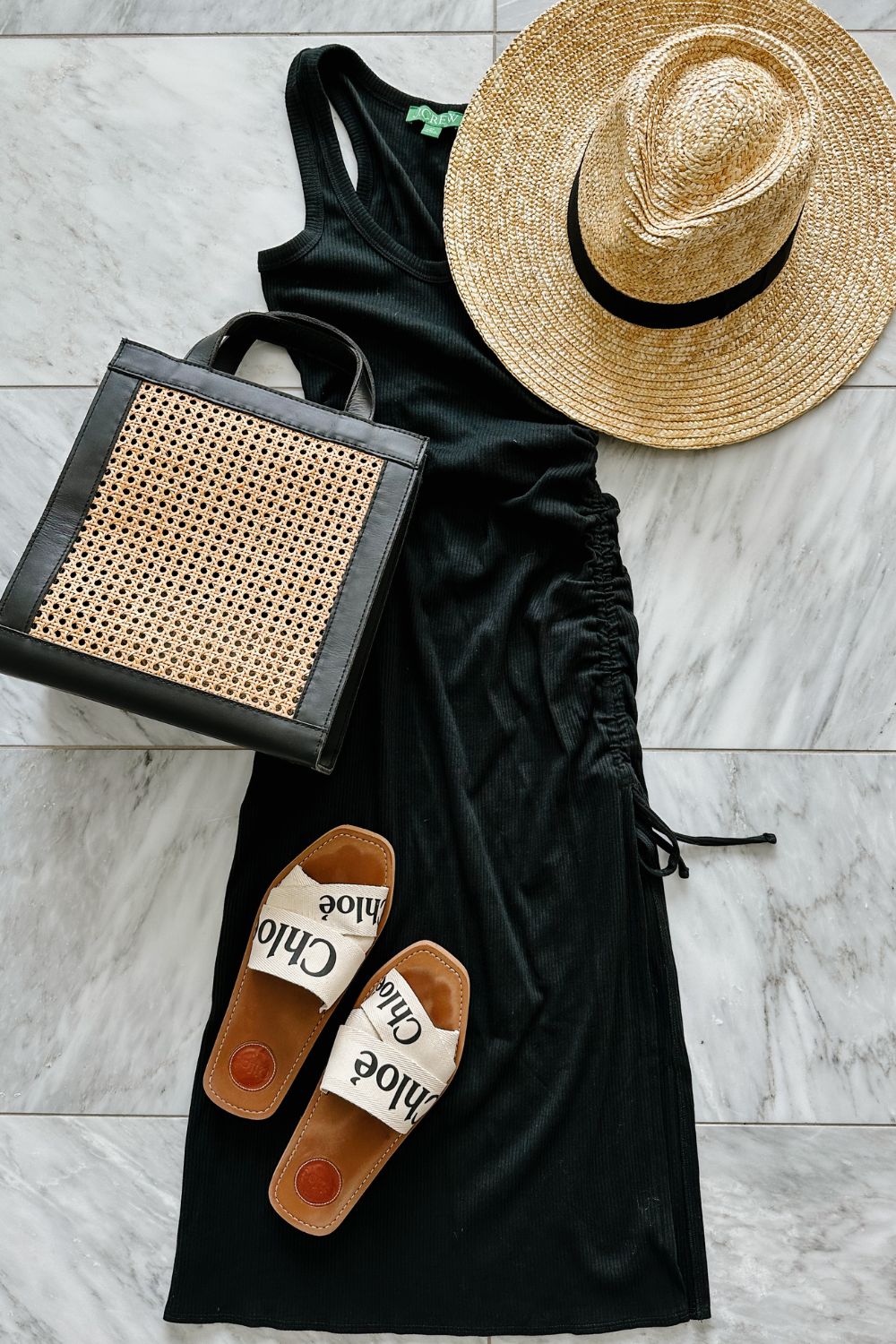 A midi dress styled with a straw hat, straw bag, and sandals 