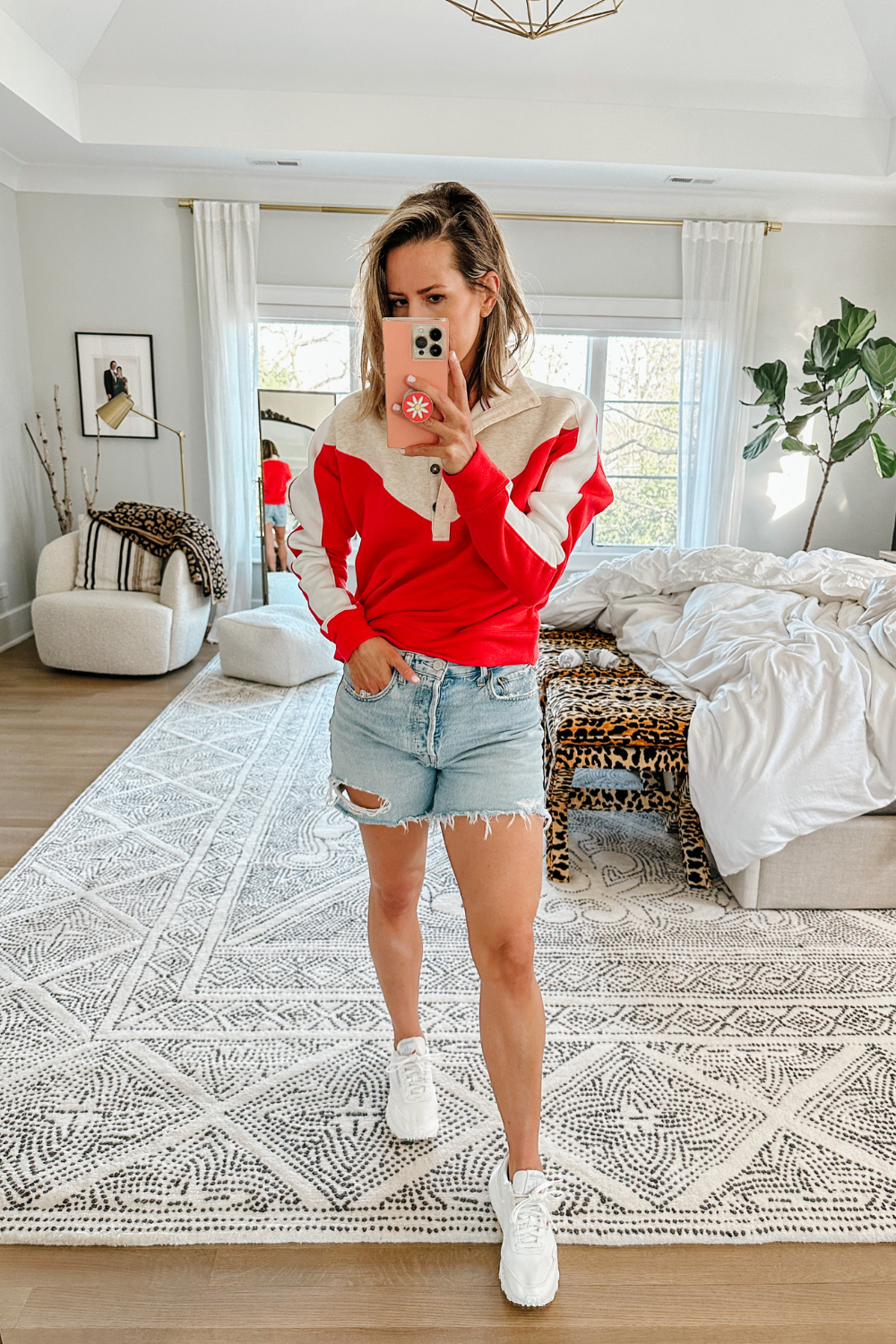 Suzanne wearing a color block pullover and denim shorts
