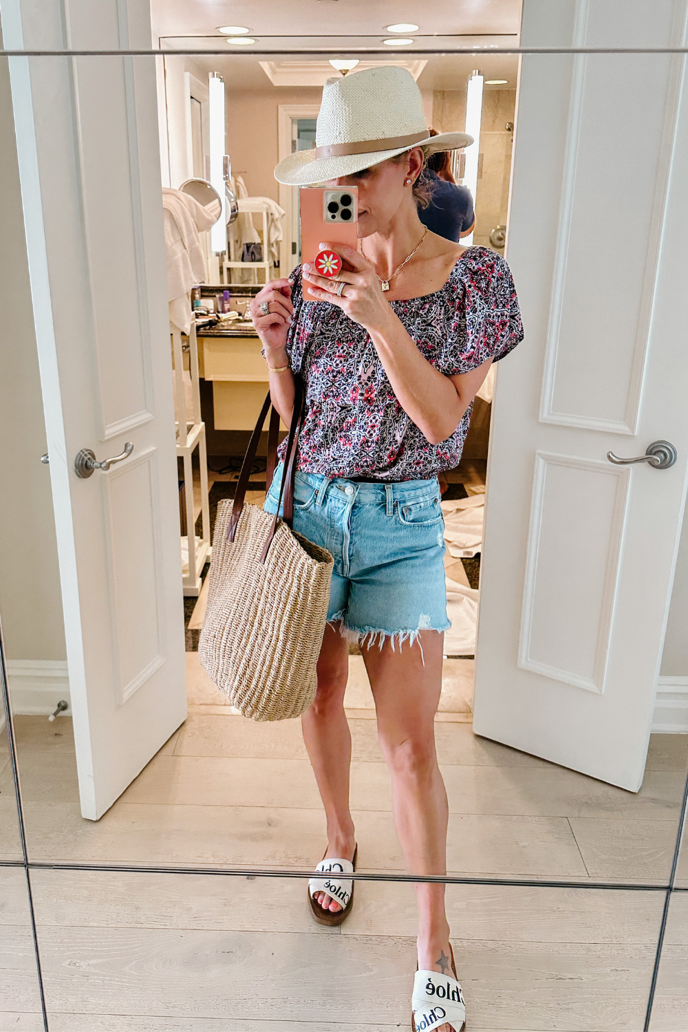 Suzanne wearing a floral top and denim shorts