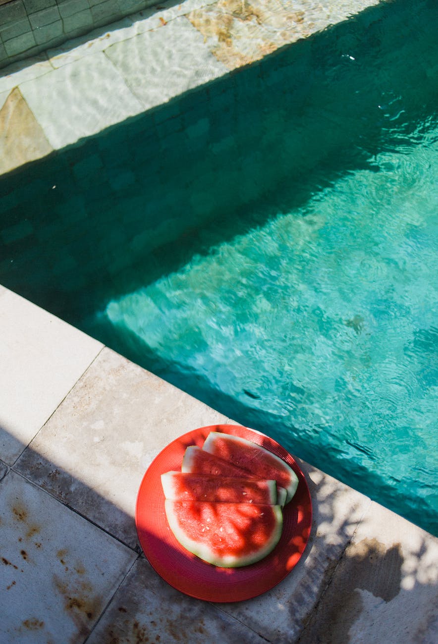 watermelon on plate by swimming pool