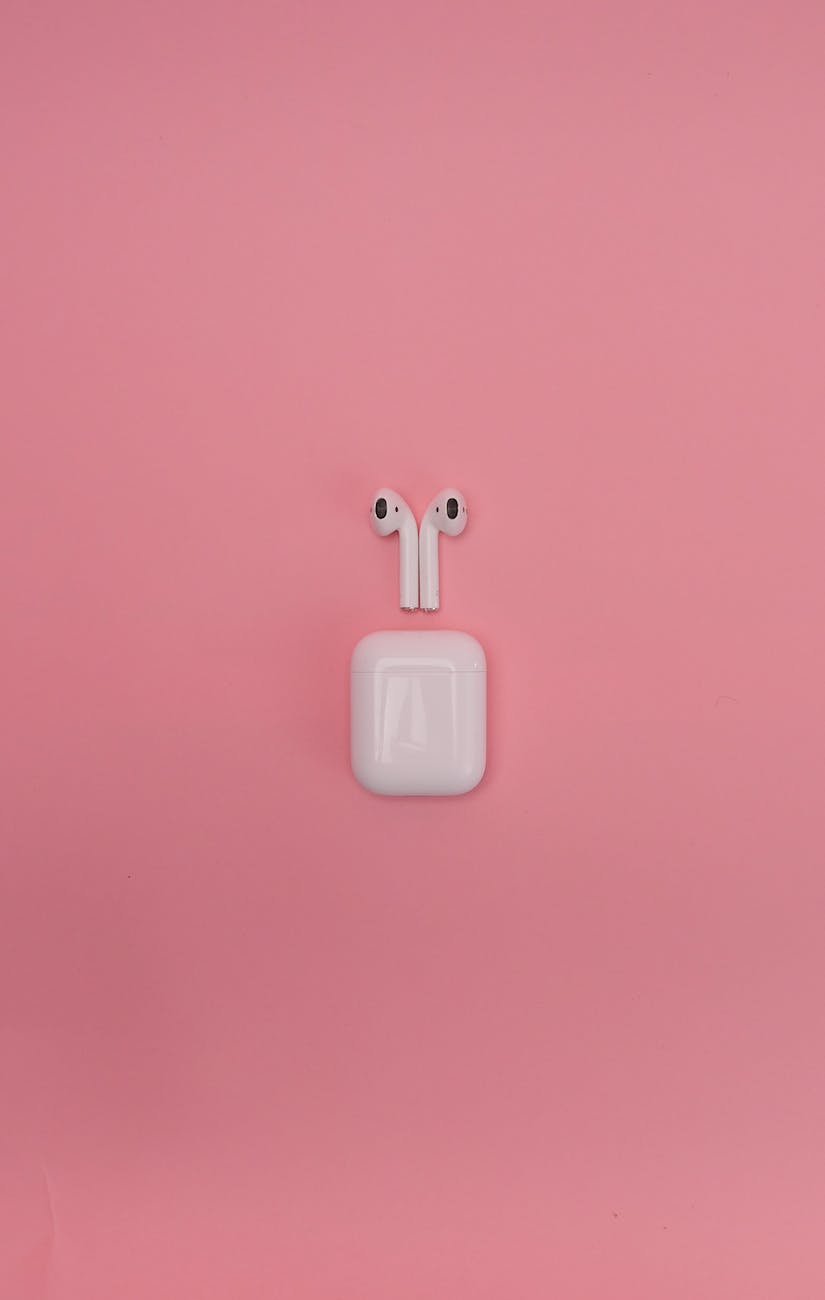 photo of airpods on a pink surface
